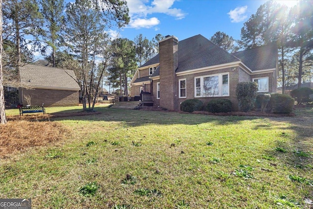 exterior space with brick siding, a yard, and a chimney