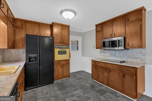 kitchen with black appliances, light countertops, and brown cabinetry