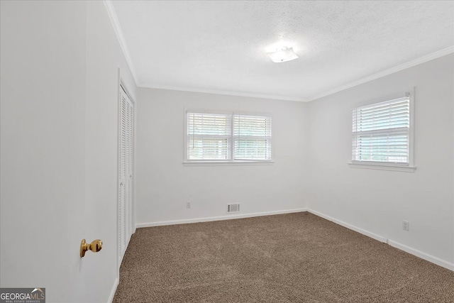 unfurnished room featuring baseboards, crown molding, dark carpet, and a textured ceiling