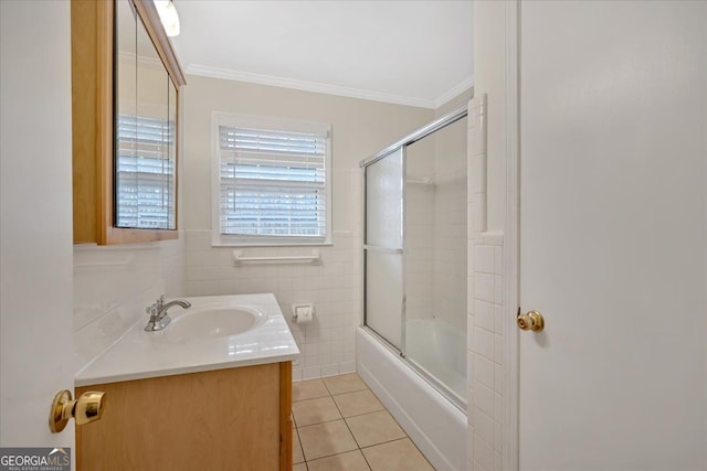 full bathroom with bath / shower combo with glass door, ornamental molding, tile patterned floors, vanity, and tile walls