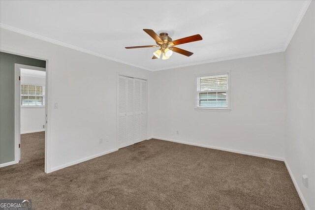 unfurnished bedroom featuring baseboards, a closet, carpet, and crown molding