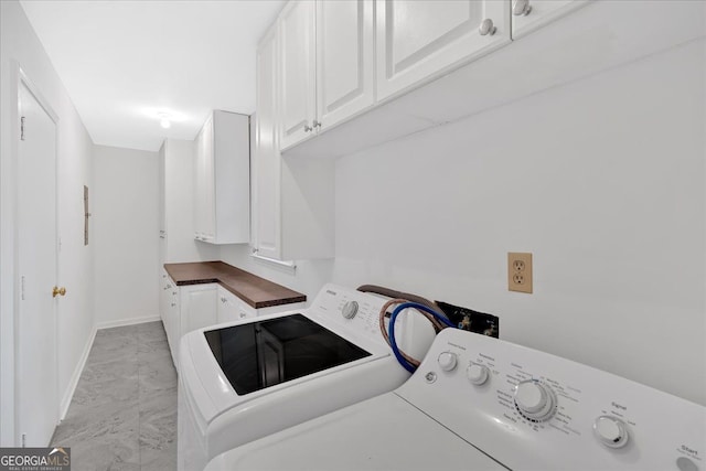 laundry area featuring cabinet space, baseboards, marble finish floor, and separate washer and dryer