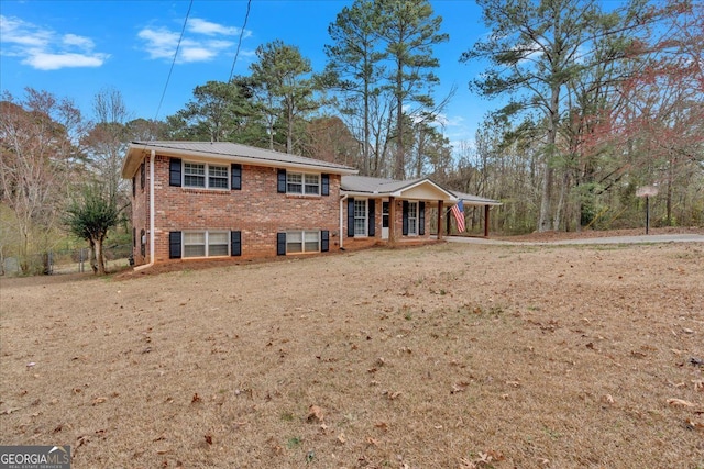 split level home featuring an attached carport and brick siding