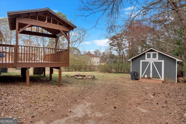 view of yard with a deck, a shed, and an outdoor structure