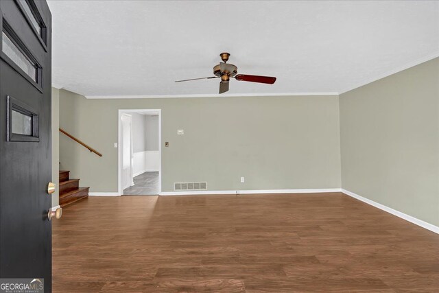 interior space featuring visible vents, crown molding, baseboards, and wood finished floors