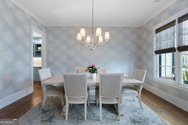 dining area featuring a chandelier, wood finished floors, baseboards, and wallpapered walls