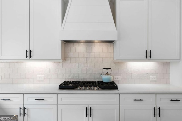 kitchen featuring light countertops, premium range hood, white cabinets, and stainless steel gas stovetop