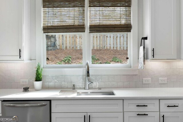 kitchen featuring a sink, white cabinets, light countertops, dishwasher, and tasteful backsplash