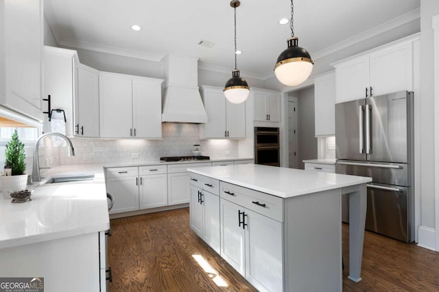 kitchen with appliances with stainless steel finishes, ornamental molding, a sink, premium range hood, and backsplash