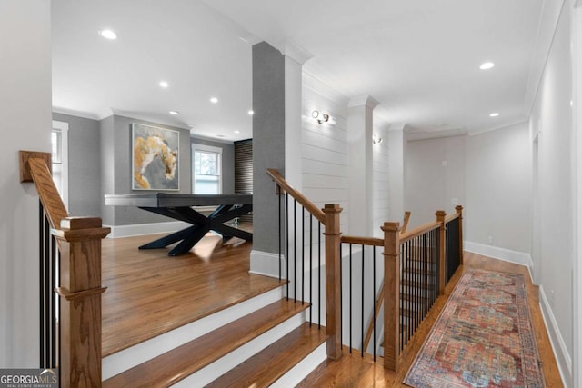 staircase featuring ornamental molding, wood finished floors, and baseboards