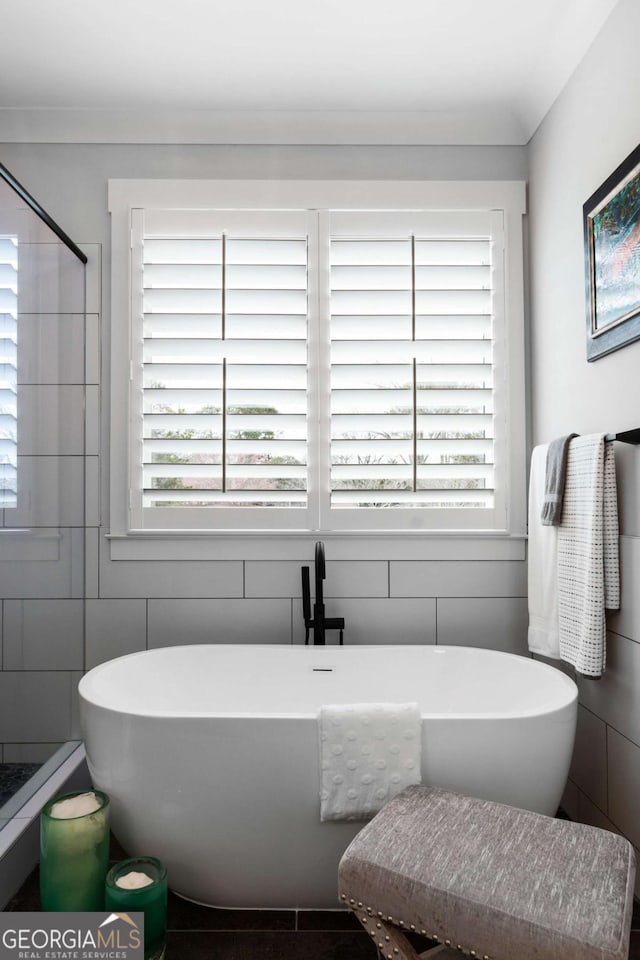 bathroom featuring a freestanding bath and tile walls