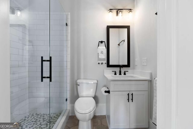 full bathroom with toilet, vanity, baseboards, a shower stall, and tile patterned floors