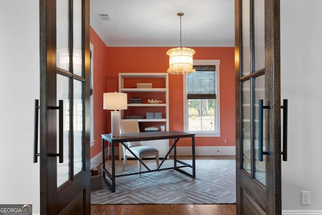 office featuring a notable chandelier, ornamental molding, wood finished floors, and french doors