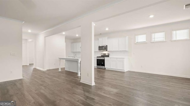 1039 Blue Juniper Cir, Loganville, GA 30052 - unfurnished living room with crown molding, dark wood-style flooring, and recessed lighting