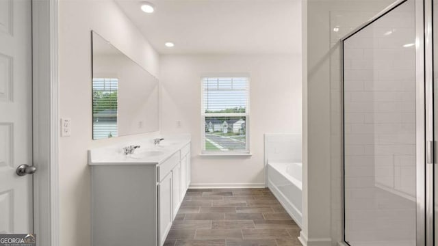 1039 Blue Juniper Cir, Loganville, GA 30052 - bathroom featuring vanity, a garden tub, a stall shower, healthy amount of natural light, and recessed lighting