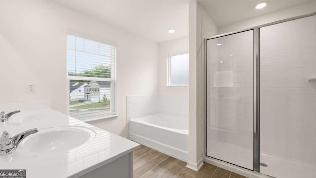 1039 Blue Juniper Cir, Loganville, GA 30052 - bathroom featuring a bath, a stall shower, wood finished floors, double vanity, and recessed lighting