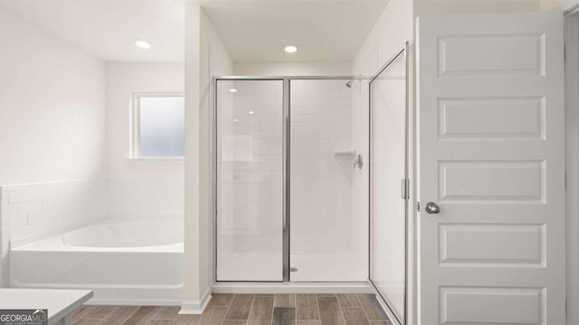 1039 Blue Juniper Cir, Loganville, GA 30052 - bathroom featuring a bath, a shower stall, and wood finish floors