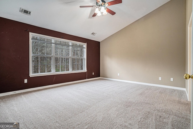 empty room with carpet, visible vents, vaulted ceiling, ceiling fan, and baseboards