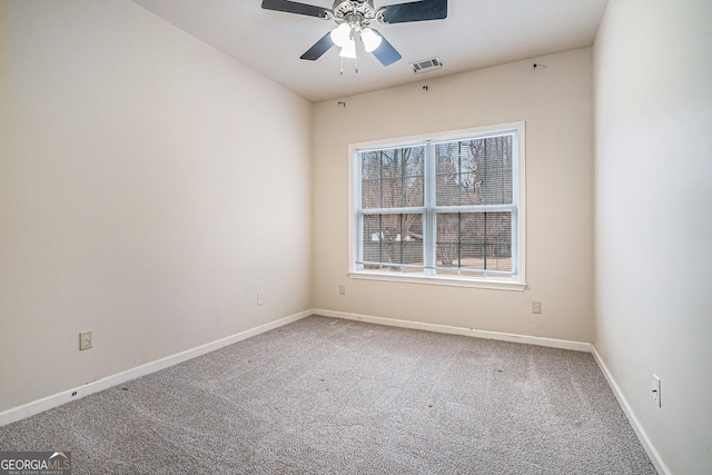 carpeted spare room with visible vents, ceiling fan, and baseboards