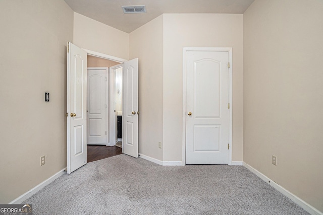 unfurnished bedroom with carpet, visible vents, and baseboards