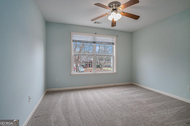 spare room featuring a ceiling fan, carpet, visible vents, and baseboards