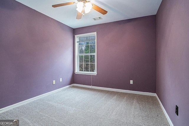 carpeted empty room with ceiling fan, visible vents, and baseboards