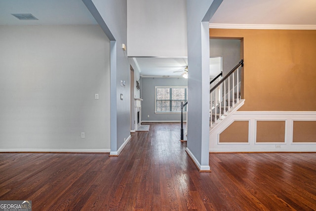 foyer with stairs, wood-type flooring, arched walkways, and crown molding