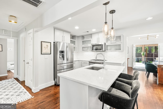 kitchen featuring visible vents, stainless steel appliances, dark wood-type flooring, and a sink