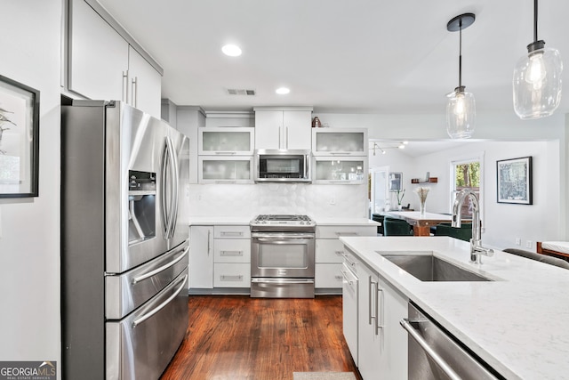 kitchen featuring visible vents, dark wood-type flooring, a sink, appliances with stainless steel finishes, and decorative backsplash