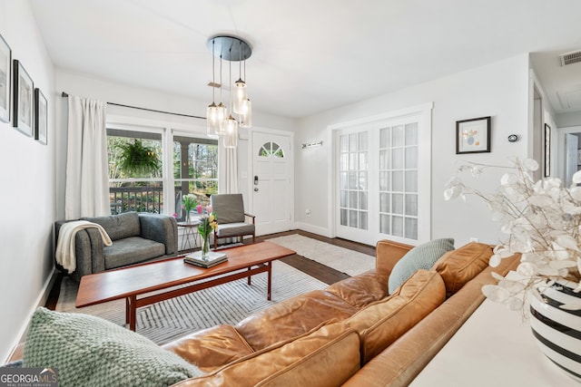 living room with visible vents, baseboards, and wood finished floors