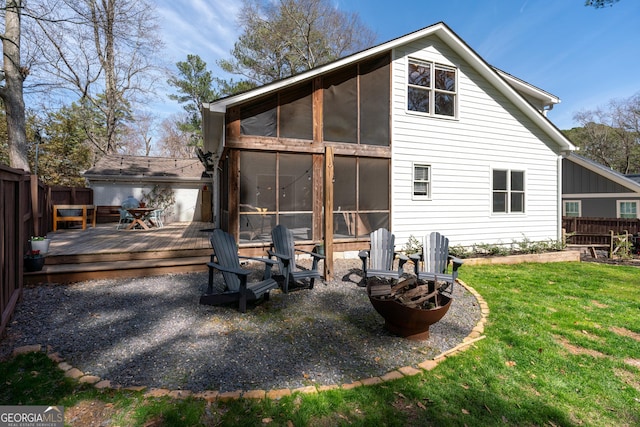 back of property with a fenced backyard, a lawn, a sunroom, and a wooden deck