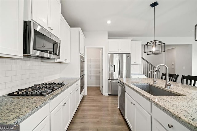 kitchen featuring backsplash, a sink, white cabinets, stainless steel appliances, and dark wood-type flooring