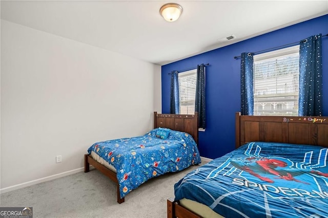carpeted bedroom featuring baseboards and visible vents