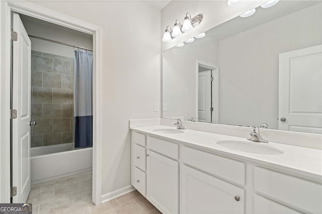 full bath with double vanity, baseboards, a sink, and shower / bath combo