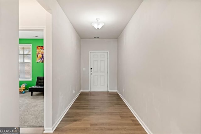 entryway with baseboards, wood finished floors, and visible vents