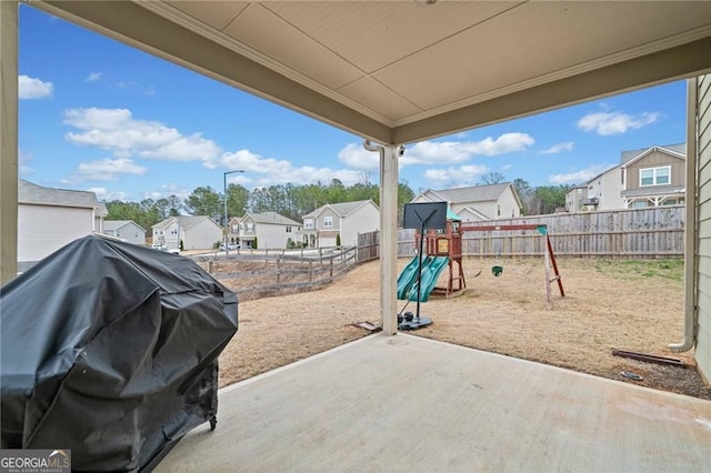 view of patio / terrace featuring a residential view, a fenced backyard, a playground, and a grill