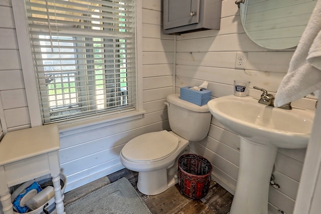 bathroom featuring wood finished floors, toilet, and wooden walls