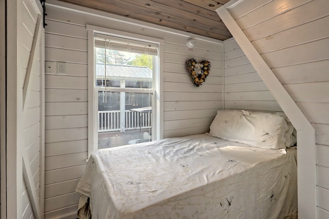 unfurnished bedroom with access to outside, wood ceiling, and wooden walls