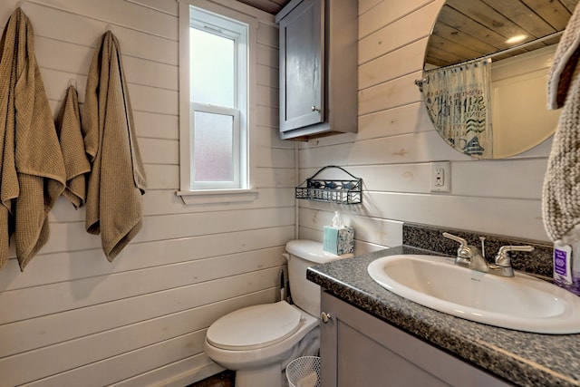 full bathroom featuring wood walls, vanity, toilet, and a shower with curtain