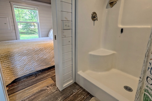 bathroom featuring wooden walls, a shower, and wood finished floors