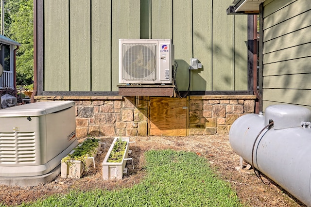 details with ac unit, a power unit, board and batten siding, stone siding, and heating fuel