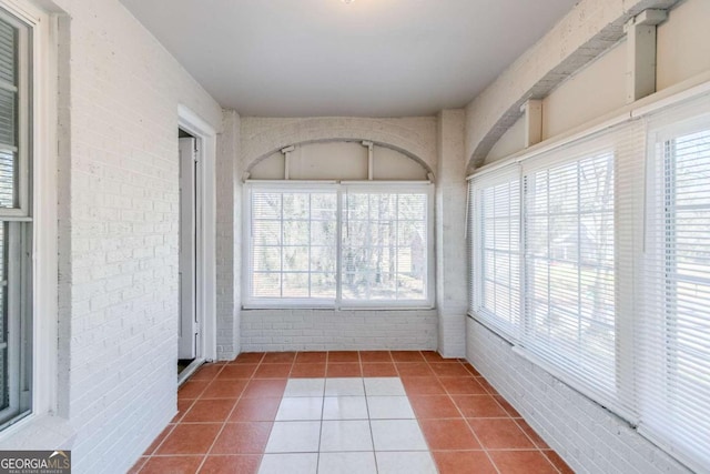 238 Howell Dr SW, Atlanta, GA 30331 - unfurnished sunroom with brick wall and tile patterned floors
