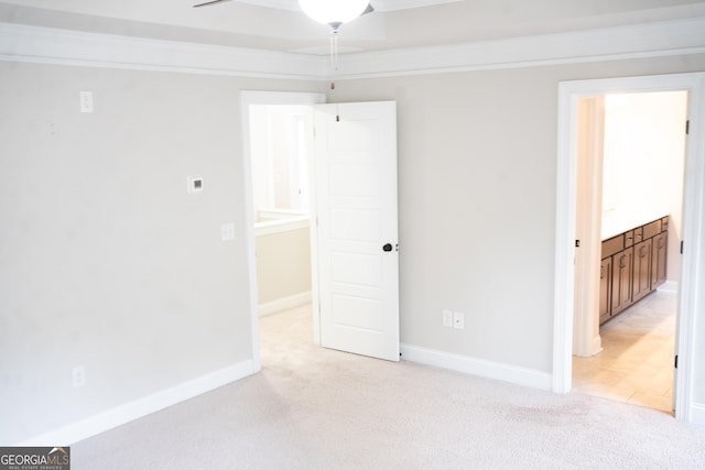 empty room with a ceiling fan, light carpet, and baseboards