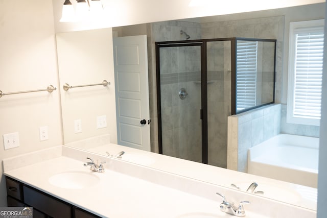 bathroom with double vanity, a stall shower, and a sink