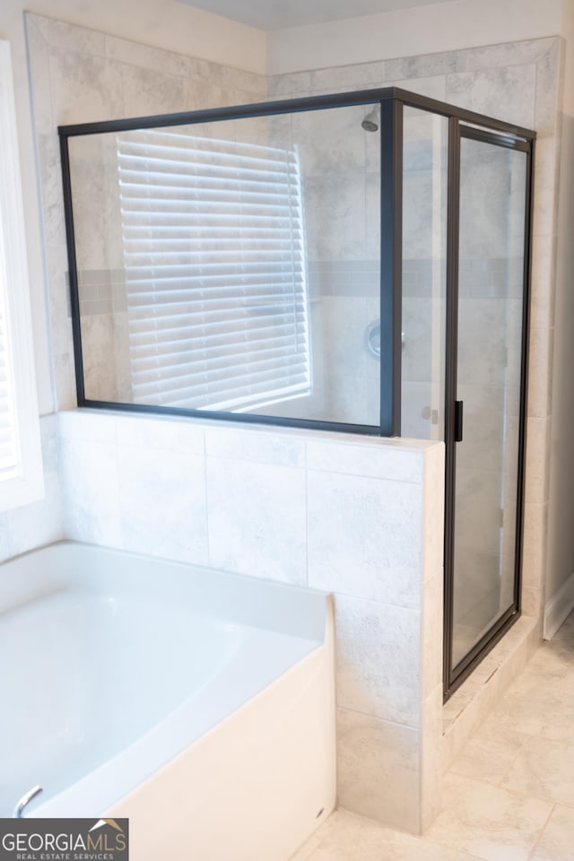 bathroom with a stall shower and a bath