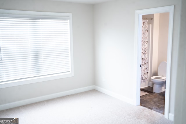 carpeted spare room featuring baseboards