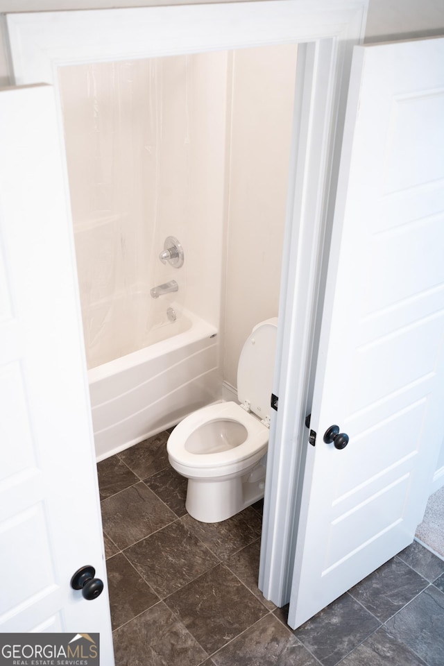 bathroom with stone finish floor and toilet