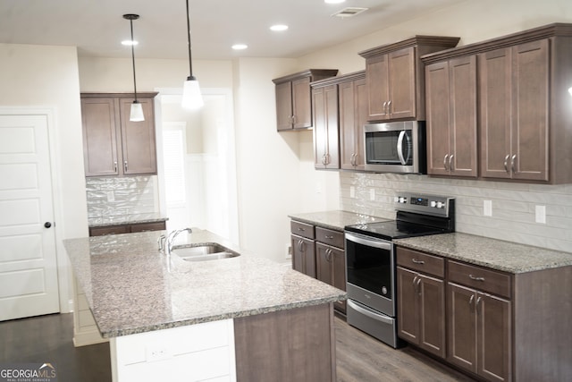 kitchen with visible vents, light stone counters, appliances with stainless steel finishes, dark wood-style flooring, and a sink