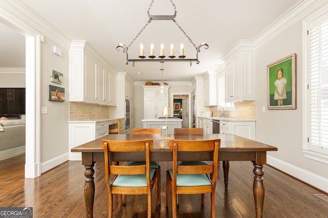 dining room with dark wood-type flooring, a notable chandelier, baseboards, and ornamental molding