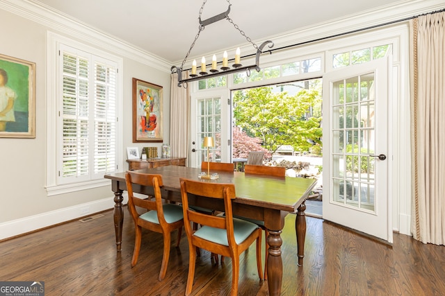 dining space featuring dark wood-style floors, visible vents, baseboards, and ornamental molding